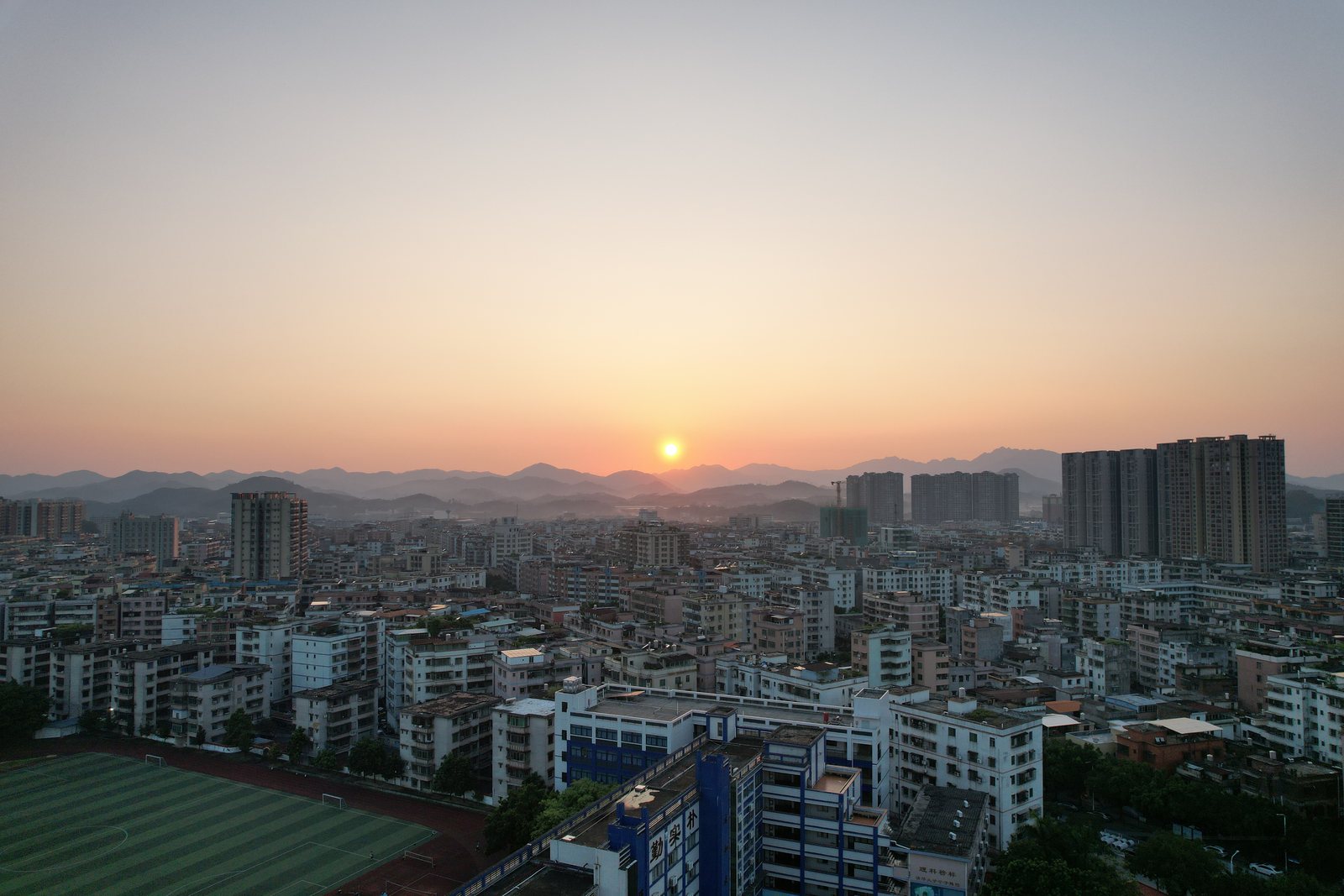 落日压在城市天际线上